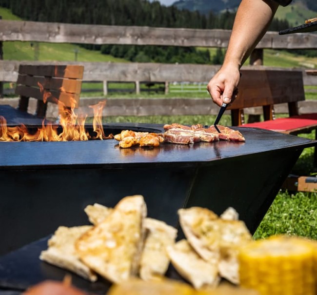 Verschiedene Fleischsorten, Knoblauchbrot, Maiskolben, Saucen, Salaten und Pommes